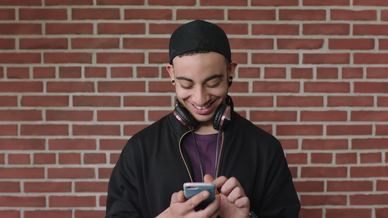 attraente giovane uomo ispanico ritratto di uno studente che usa uno smartphone messaggi di testo navigazione