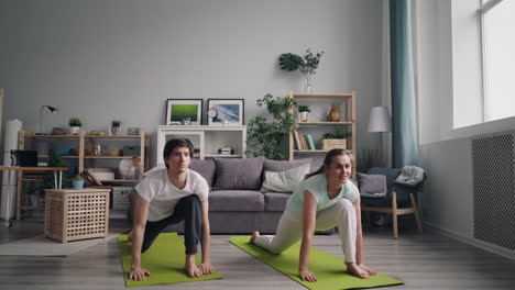pareja practicando yoga en casa