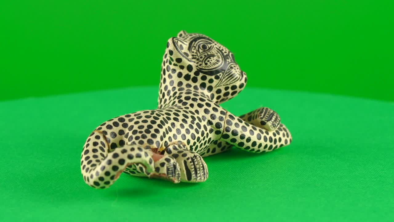 Mexican handcraft of jaguar god deity maya aztec symbol on green background chroma key background replacement backdrop objet in a turntable 3d spinning loop