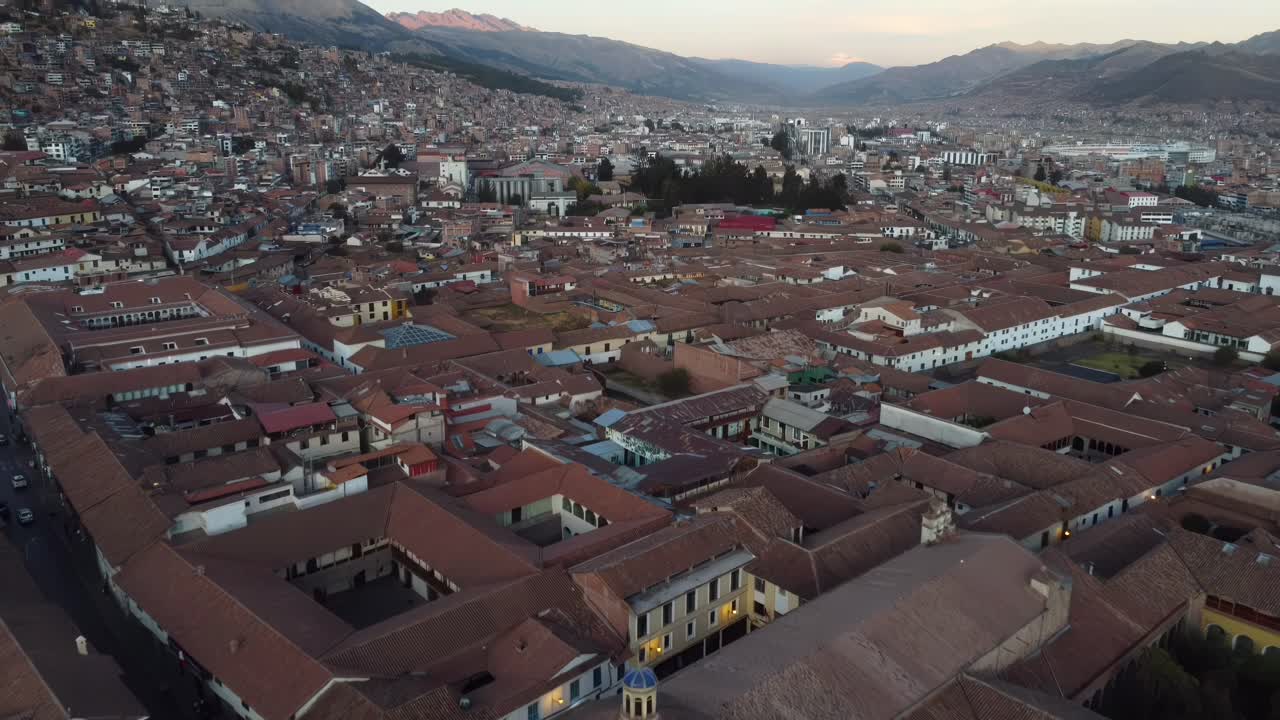 Aerial establishing overview of the rooftops of Cuzco, Peru, with the Andes mountains in the distance