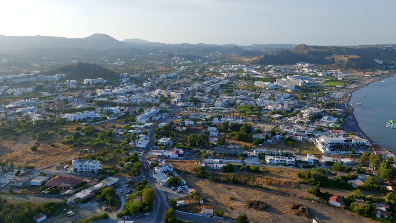 Aerial flyover the townscape of Faliraki village, sunny evening in Rhodes, Greece