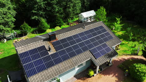 Disparo-De-Un-Dron-Que-Rodea-Una-Casa-Fuera-De-La-Red,-Alimentada-Por-Colectores-De-Luz-Solar,-Un-Día-De-Verano