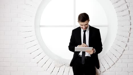 a young man in a black suit uses a digital tablet pc