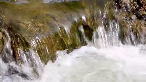 Close-Up-Shot-Of-Water-Running-Over-Rocks-And-Coming-To-A-Small-Waterfall-After-The-Rain