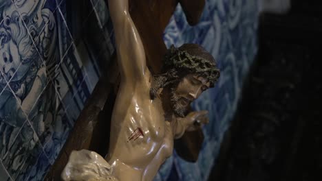 Jesús crucificado con dolor cerca de azulejos azules dentro de una iglesia antigua
