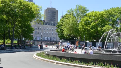 people are enjoying the sunny weather at a fountain in quebec city