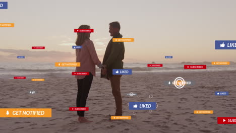 animation of social media text and icons over caucasian couple on beach