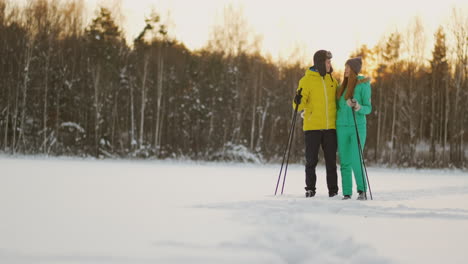 Im-Winterwald-Fahren-Bei-Sonnenuntergang-Ein-Mann-Und-Eine-Frau-Ski-Und-Schauen-Sich-In-Zeitlupe-Die-Schönheit-Der-Natur-Und-Der-Sehenswürdigkeiten-An.