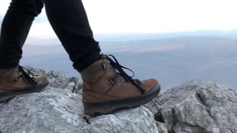 Mujer-De-Pie-Sobre-Una-Roca,-Vestida-Con-Calzado-De-Montaña-Y-Jeans-Negros