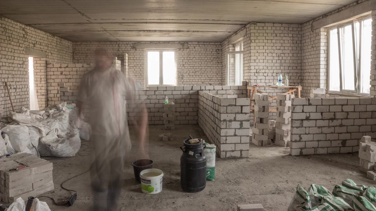 Construtores assentando paredes de tijolos dentro de apartamento com ferramentas profissionais em timelapse. Trabalhadores em ação, pedreiros construindo parede, empreiteiro e operário. Materiais de construção ao redor