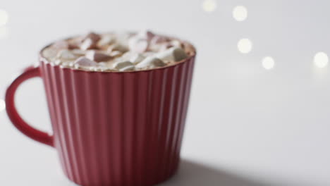 video of red mug of christmas chocolate with marshmallows and copy space on white background