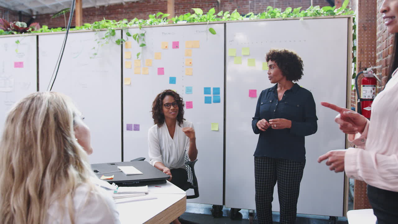 Team creativo femminile in riunione per discutere idee in un ufficio moderno.