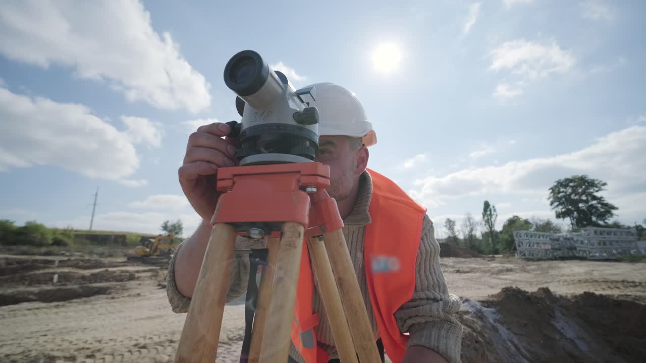 un ingeniero topógrafo toma mediciones en la construcción de una subestación de transformador