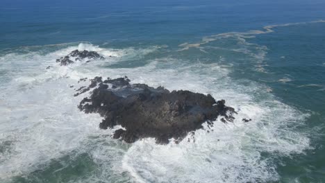 aerial view of powerful sea waves hits coral rock