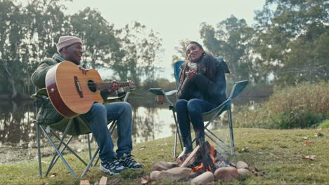 camping, fire and guitar with a musician couple