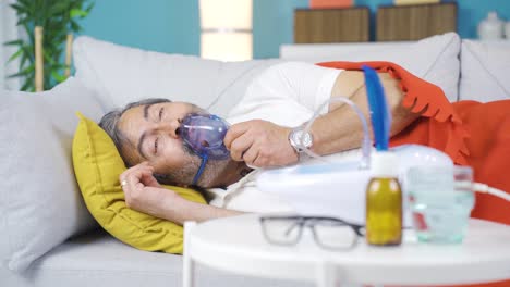 hombre acostado en casa respirando con un respirador.