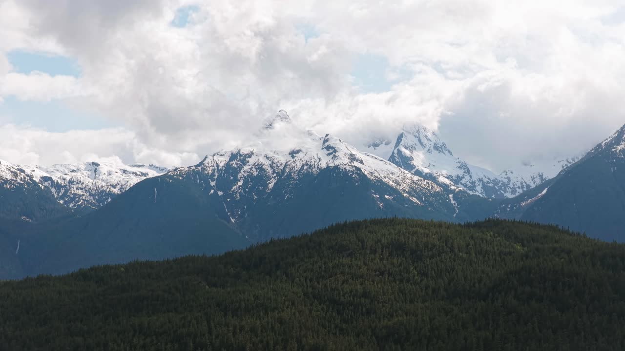 Cime montuose innevate e foreste verdi lussureggianti nella Columbia Britannica, Canada