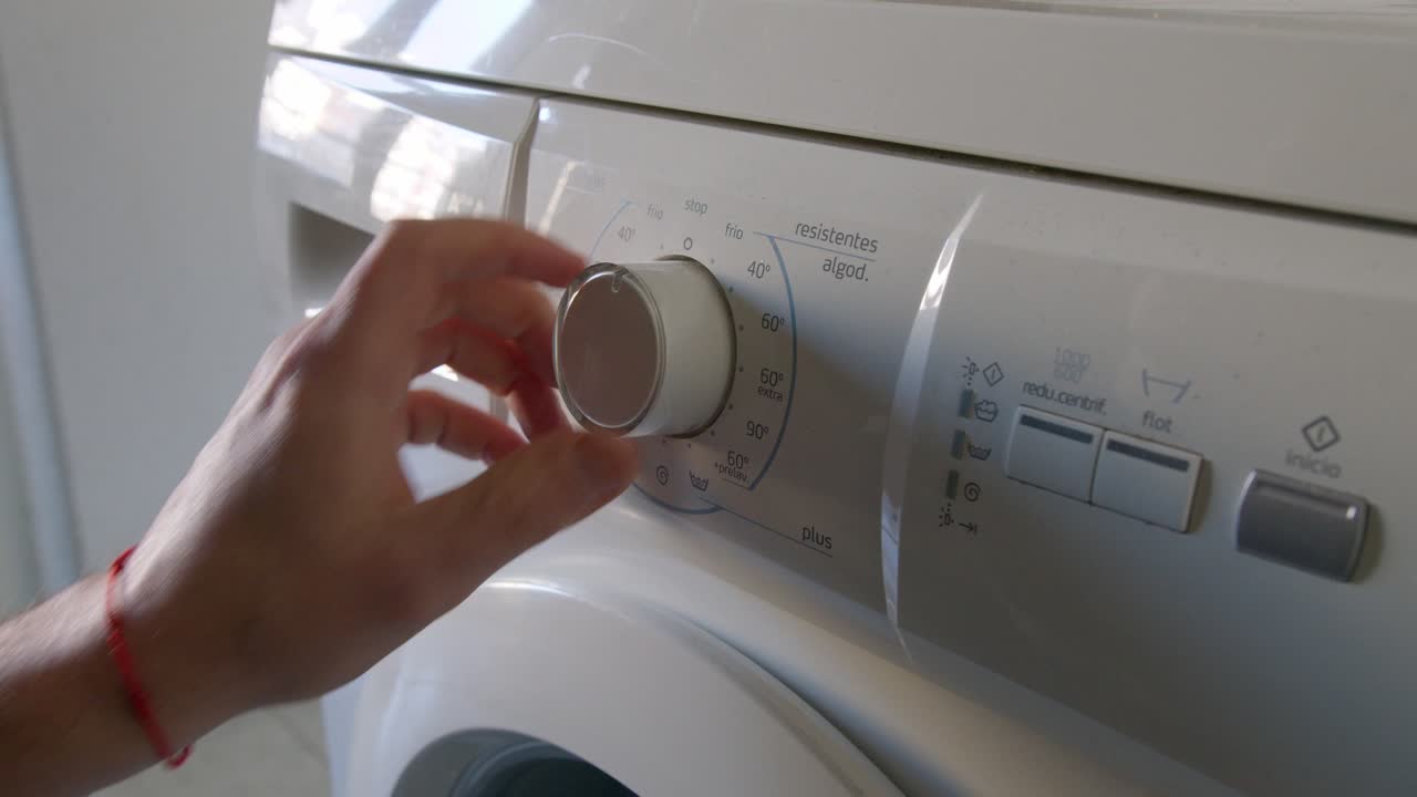 Setting Washing Machine Program, Starts Doing Laundry at Home, Press Button, Detail Shot
unrecognizable man