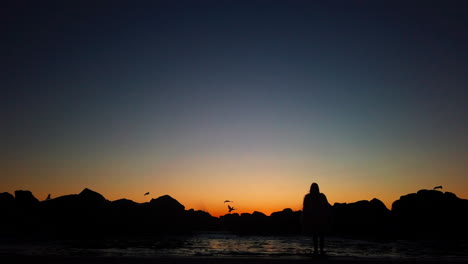 Mädchen,-Das-Bei-Sonnenuntergang-In-Zeitlupe-Am-Kalifornischen-Strand-Steht