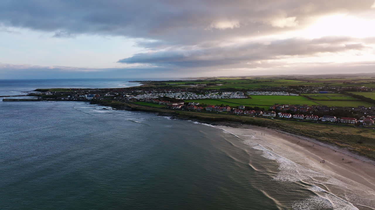 4k órbita lenta de las casas de mar puerto, reino unido al atardecer