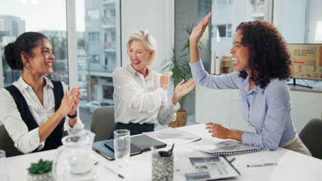 businesswomen celebrating success with a high five in the office