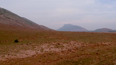 vista árida de una zona rural remota aislada con montaña y cielo plano