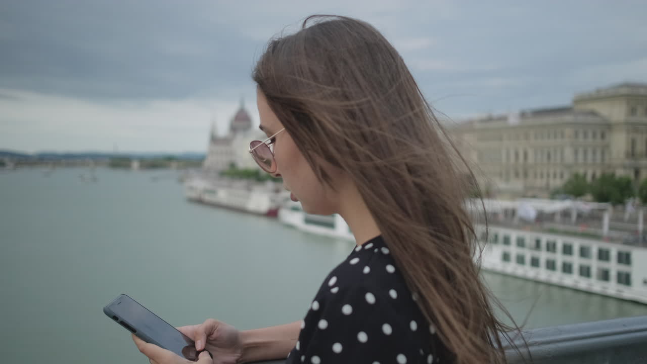 joven usando el teléfono en un puente en budapest