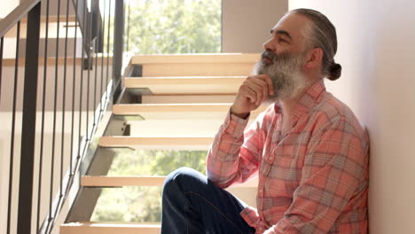 thinking deeply, senior man sitting on stairs in casual attire