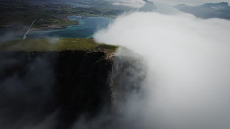 cinematic fpv drone shot stabilized from lofoten diving down a cloud covered ridge