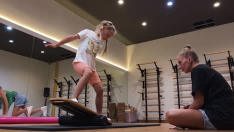 children practicing balance on balance board