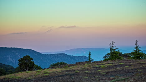 High-rocky-mountains-and-clouds-flowing-nearby,-vibrant-colorful-sky,-time-lapse