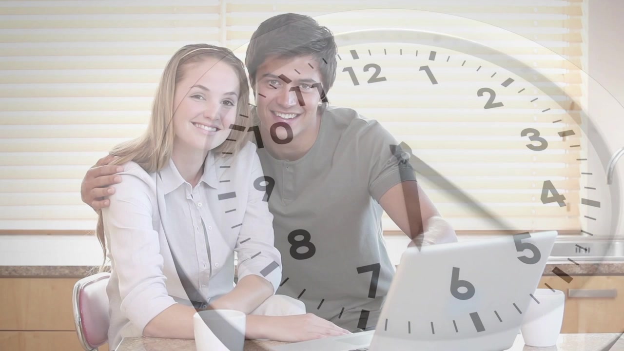Man pointing at laptop, woman typing for finance planning in kitchen, clock overlay advancing time