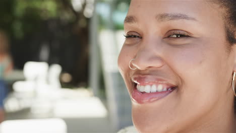 primer plano de una joven biracial sonriendo al aire libre con espacio para copiar