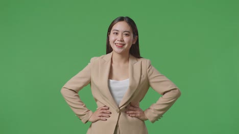 스튜디오 의 초록색 스크린 배경 에 따뜻 한 미소 를 지는 아시아 의 사업가