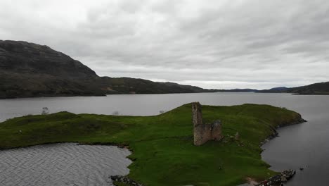 Toma-Aérea-Hacia-Arriba-Del-Castillo-De-Ardvreck-Escocia-Con-Un-Fondo-De-Cielo-Cambiante