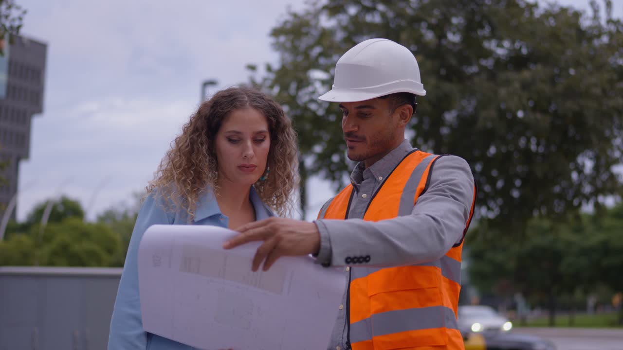 Construction Team Reviewing Blueprints on City Street