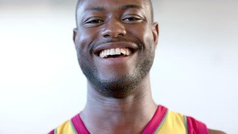 a young african american basketball player smiles broadly, showcasing a joyful expression