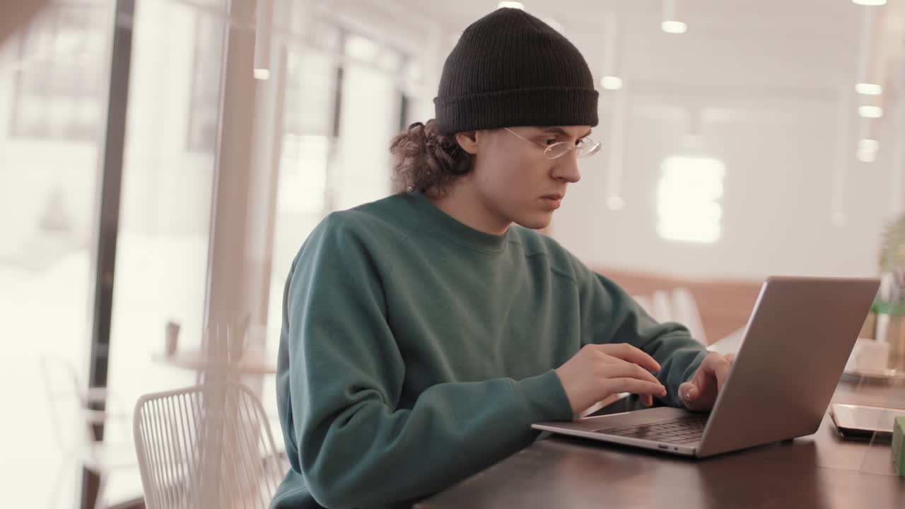 Young people working on laptops in a cafe