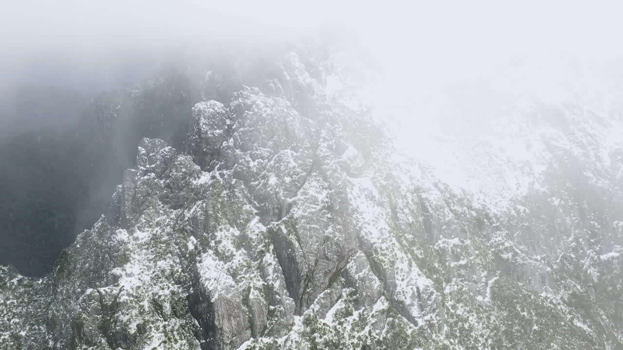 태즈메이니아 서해안의 인상적인 산들 위로 안개 낀 구름 사이로 날아가는 이른 아침 드론 영상