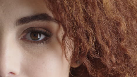 close up of young woman eye looking at camera blinking surprise expression