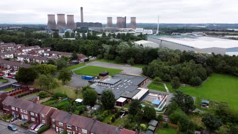 british industrial residential neighbourhood aerial view across power station suburban houses and streets rising shot