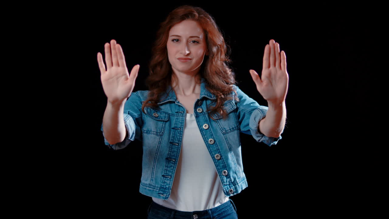 una joven mujer caucásica extiende las manos y dice que no