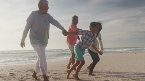 Felices-Abuelos-Y-Nietos-Hispanos-Corriendo-En-La-Playa-Al-Atardecer