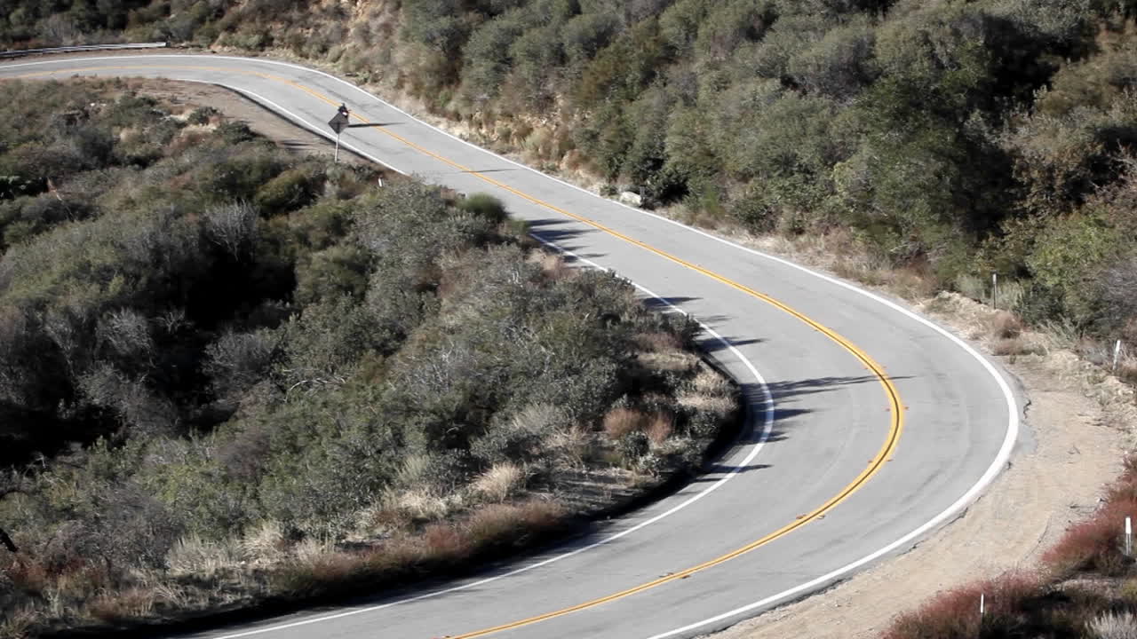 구불구불한 산길을 달리는 오토바이와 자동차 1