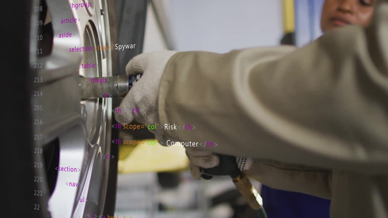 Animation of mechanic working on car wheel with coding text overlay in garage