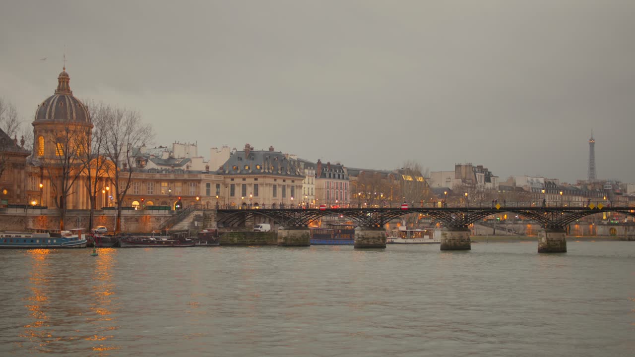 Paris city skyline with Pont des Arts bridge on cloudy autumn evening
