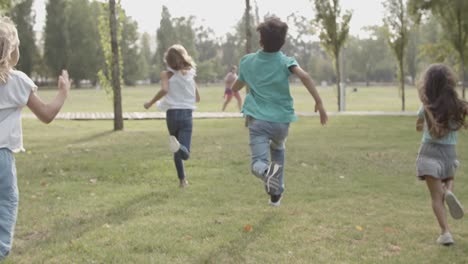 back view of children running and competing in speed in the park