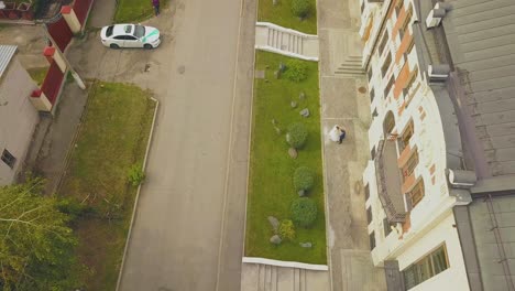 newlywed couple hugs near building on street aerial view