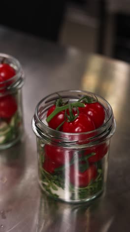 tomates de cereza en frascos de vidrio