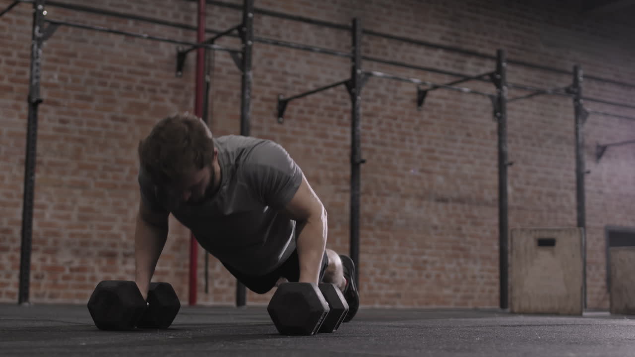 Athletic Man Doing Push Ups on Dumbbells